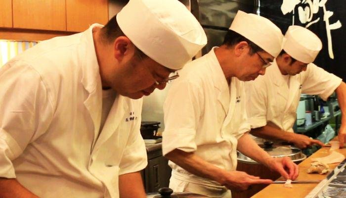 Chefs from Yoshino Sushi preparing omakase sushi in Tokyo